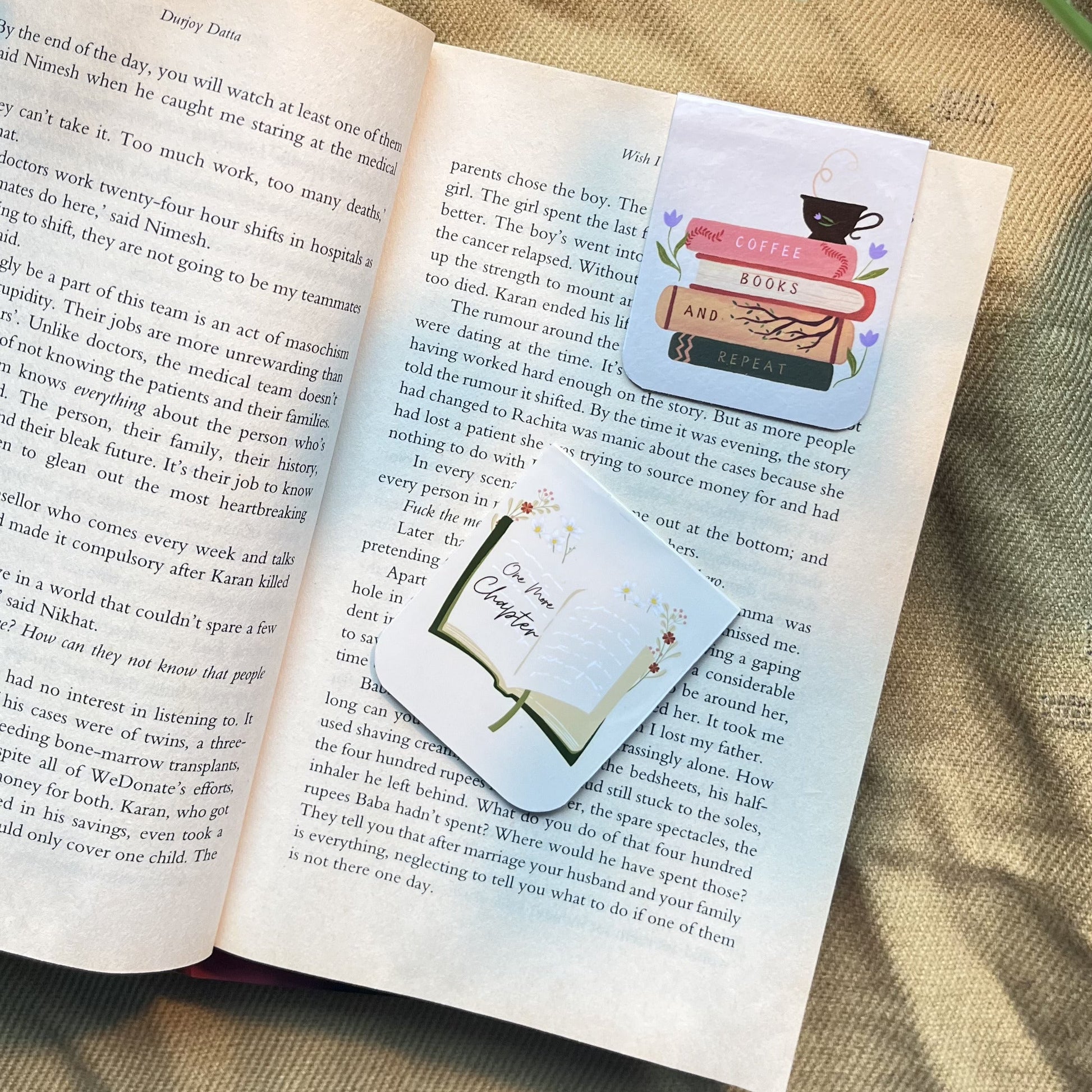 Open book with a decorative bookmark on a textured surface with flowers.